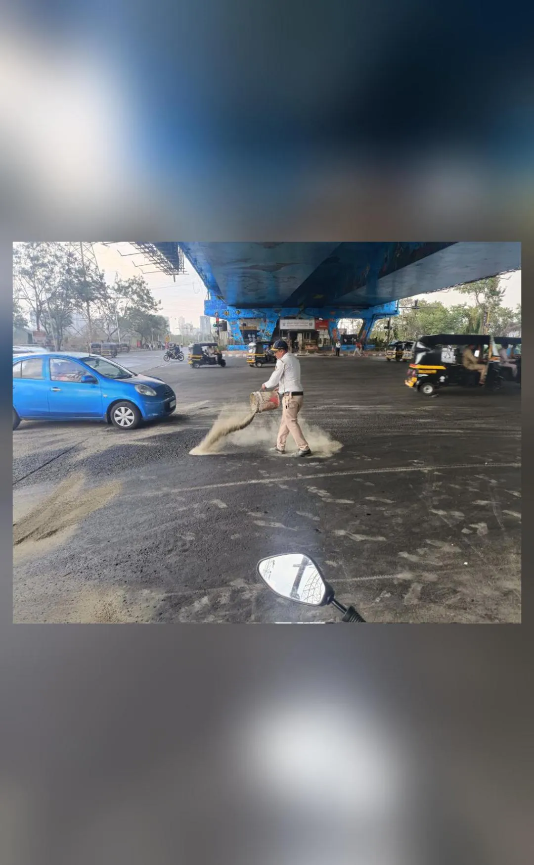 मुंबई ट्रैफिक पुलिसकर्मी फिसलन भरी सड़क पर बालू छिड़कते नजर आया... सोशल मीडिया पर वायरल हुई फोटो