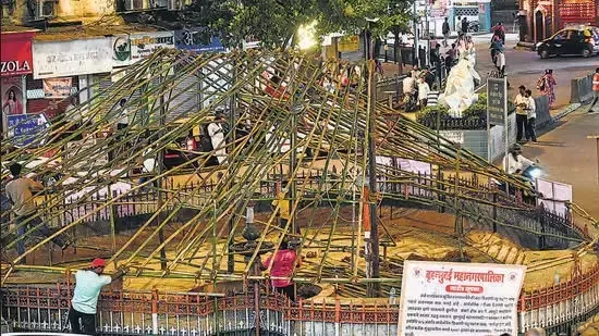 दादर के कबूतरखाने में नगर निगम कर्मचारियों द्वारा बड़े-बड़े प्लास्टिक के चादरें बिछाए जाने के दौरान बेचैन भीड़ को नियंत्रित किया